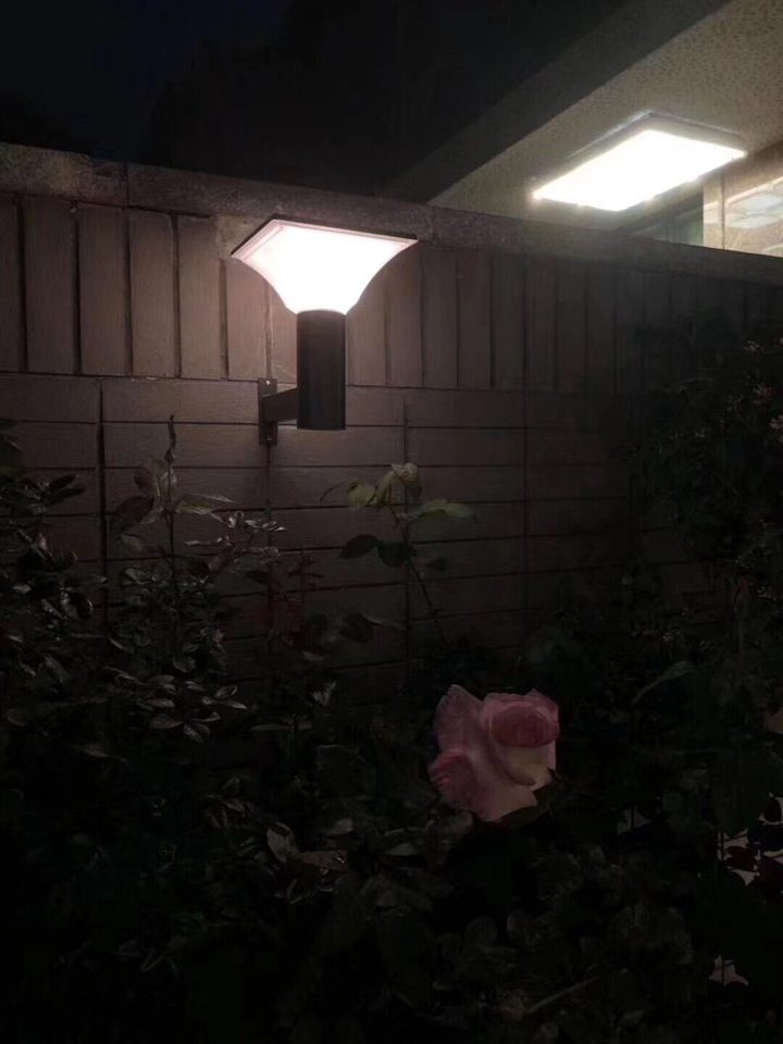 Square opaque lamp head on a right-angle wall bracket at night