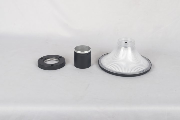 Round ribbed lamp head beside a separate sleeve and flange