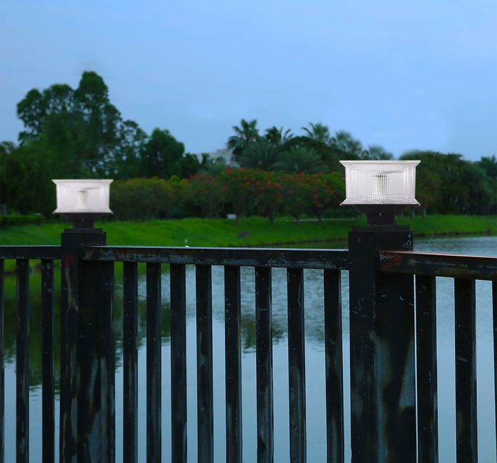 Illustration of two square lamps on railing posts beside water