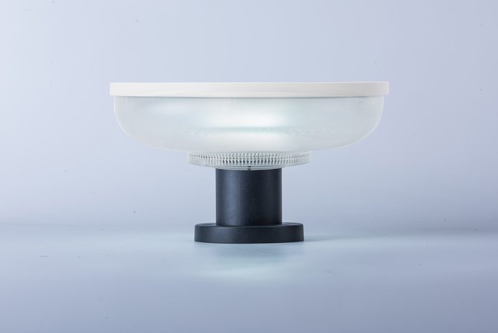 Compact round-head lamp on a short pedestal, pictured illuminated.