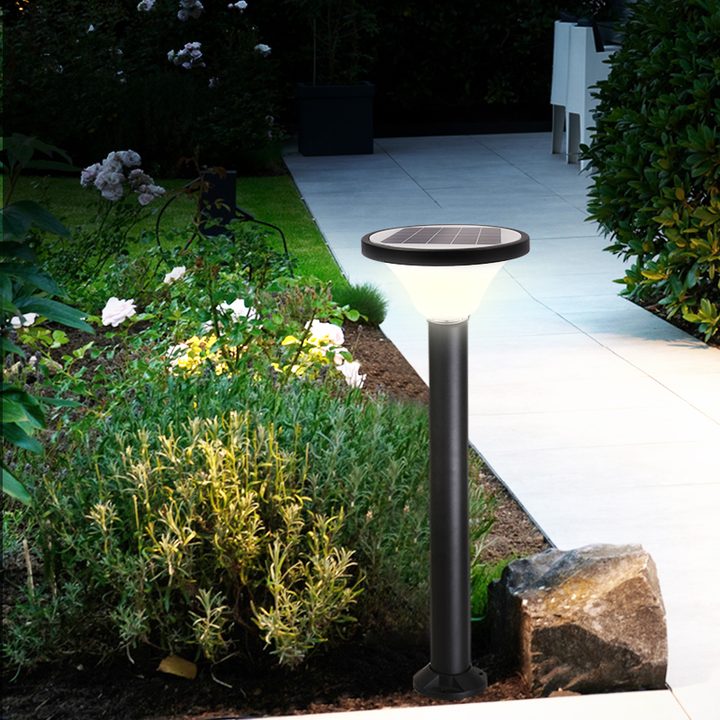 Round-top lamp with a shaped base in a garden-edge illustration.