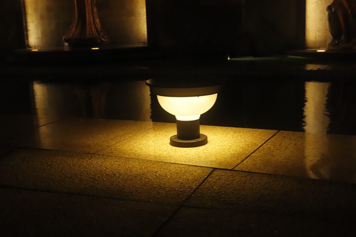 Short bowl-shaped lamp illuminated on a stone ledge