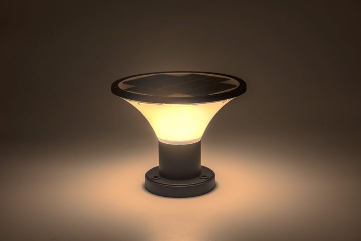 Smooth round lamp pictured with a warm-looking illuminated shade.