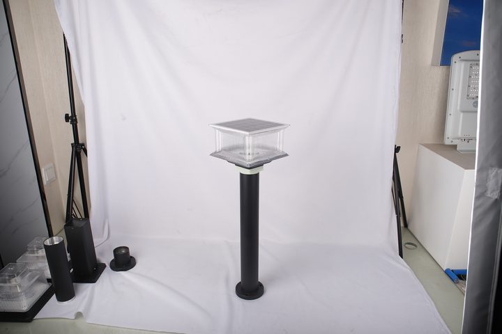 Studio view of a square-head lamp with a pale collar above a cylindrical post.